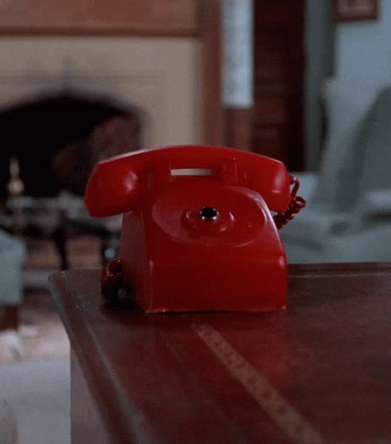 a red telephone is sitting on a table in a room