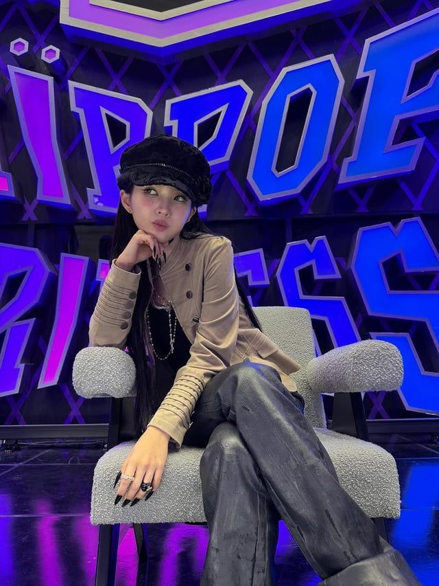 soyeon from i-dle sitting in front of a sign for the show hippop princess