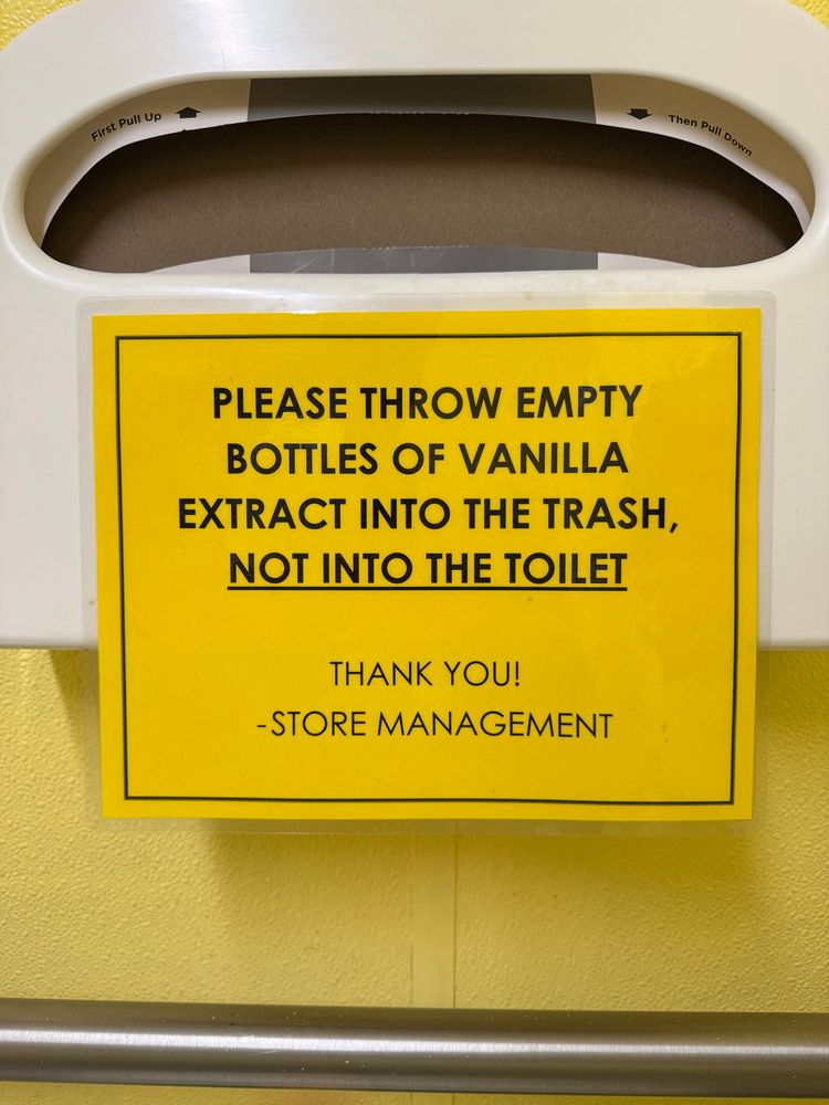 Sign reading:
PLEASE THROW EMPTY BOTTLES OF VANILLA EXTRACT INTO THE TRASH, NOT INTO THE TOILET
THANK YOU!
-STORE MANAGEMENT