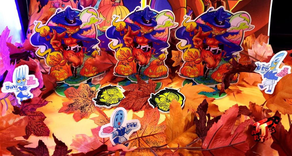 A series of photos showing off the various items I have in my shop: H. Spirit standees, posters, wallscrolls, keychains, and much more when you go to the "Fall & Halloween" section of virtual-k.com. The first image shows a screenshot of my online shop with the Fall decor on. 2nd image shows the H. Spirit glow in the dark items; standees and keychains with a bunch of faux autmn leaves and VK staff scattered around them. 3rd image: A vertical shot of the standees and keychains in half-darkness now in front of the H. Spirit posters. 4th image shows the H. Spirit standees and keychains glowing brilliantly in pitch darkness! | The following emoji is just for my art feeds: 🍞🛒 | 🍞🎨 | 🎃🍁 | 💥👧