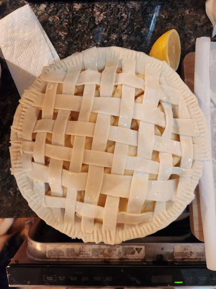 Apple pie with lattice work done by someone who clearly kicked in the head by a horse