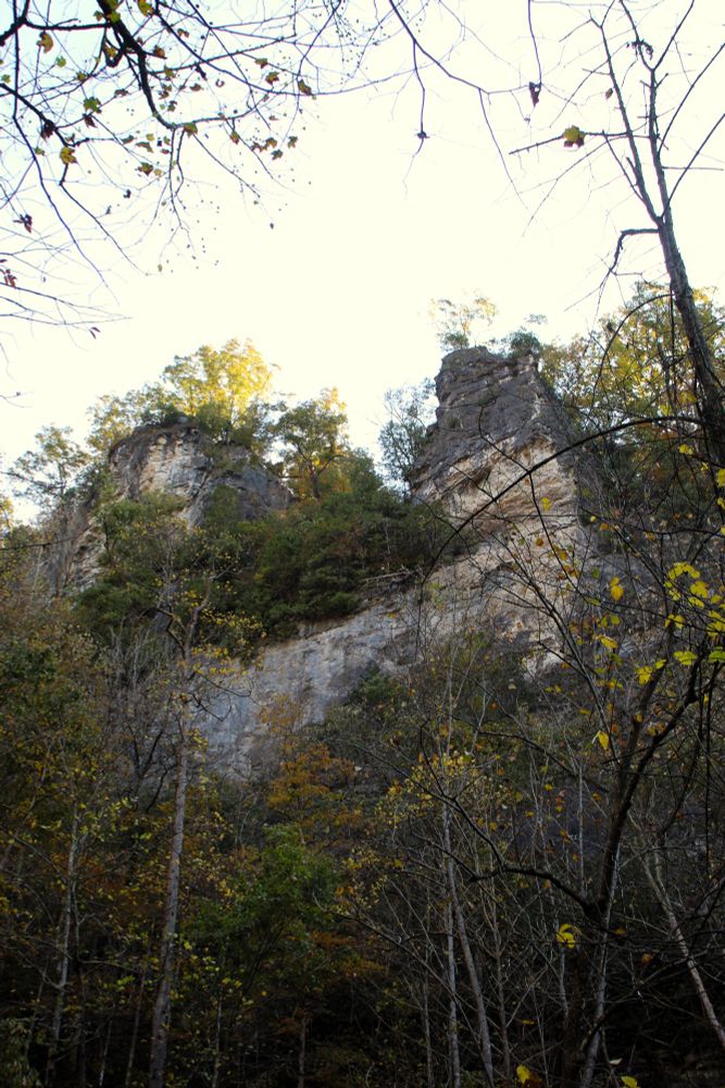 Two large stone outcrops rise from a cliff face.
