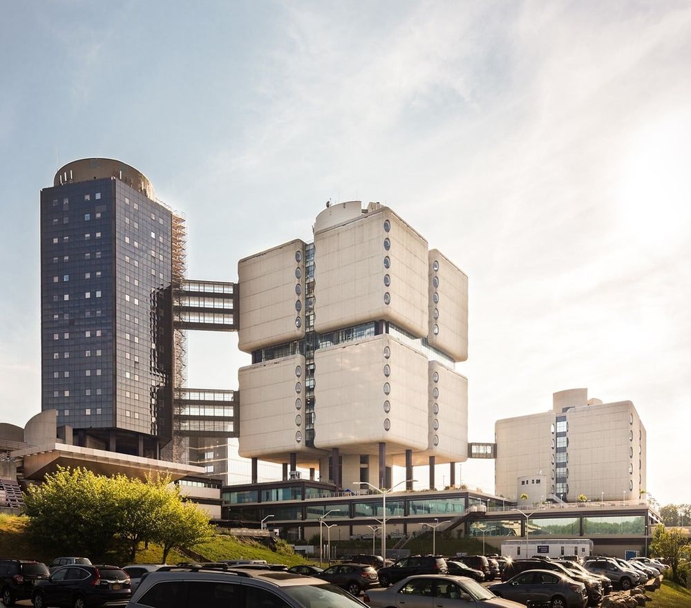 A cubic, concrete building with oval windows only on the corners. 