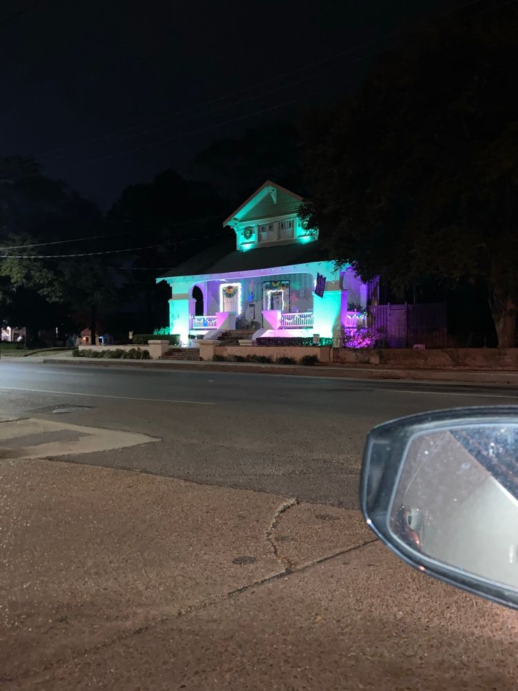 Houses lit in purple, green, and gold 