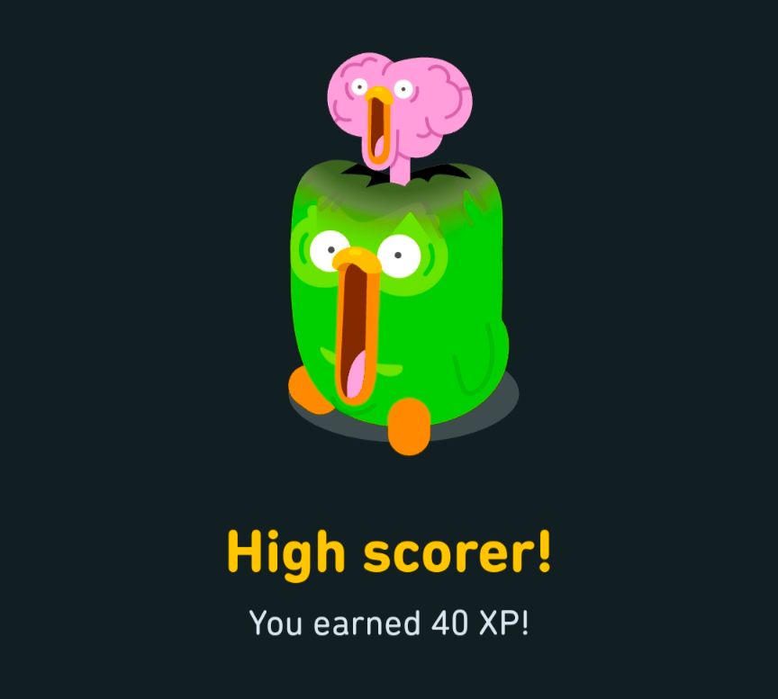 Duo, the green owl mascot for Duolingo, is seen with wide eyes and an open beak, which reaches the ground. A pink brain explodes from the top of duo's head with a face mimicing the expression on Duo.