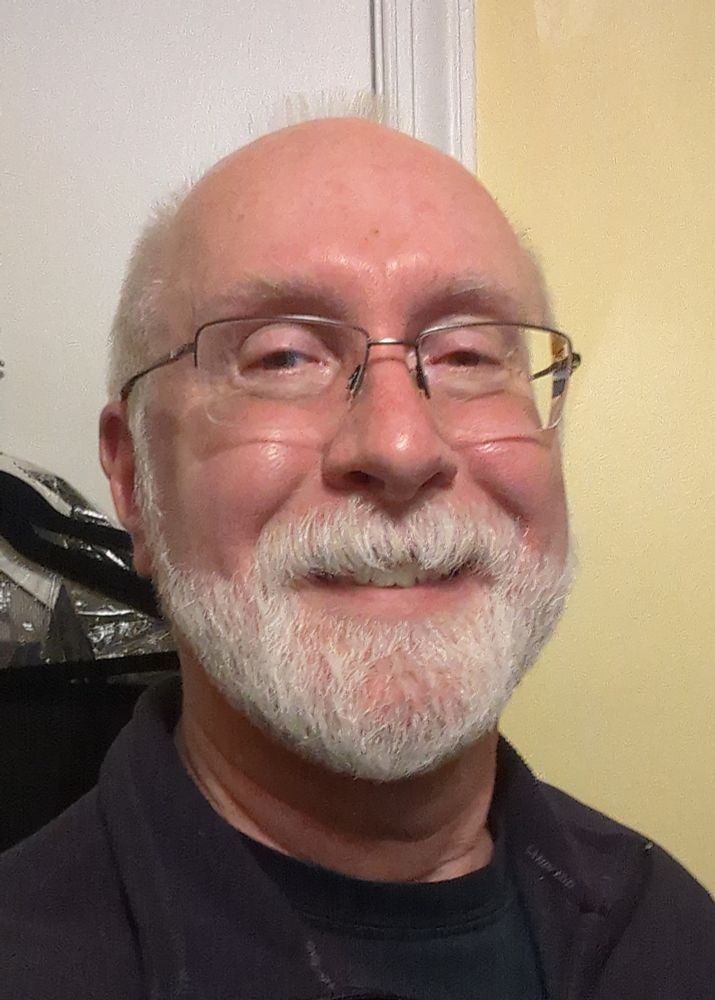 Old guy selfie on a white & yellow indoor background.