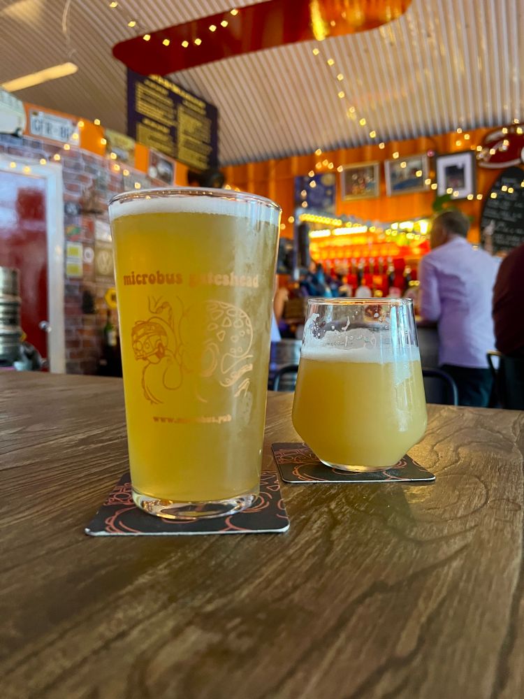 Two hazy beers sat on a table in Microbus Gateshead