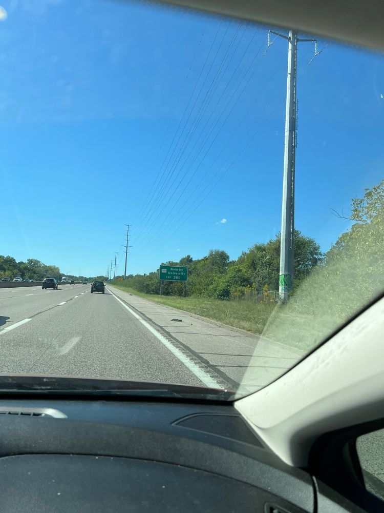 Picture of all entirely blue sky taken from the highway, EXCEPT one very small cloud if you look close. 