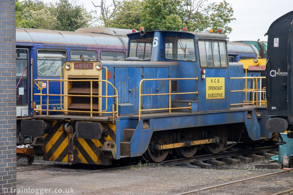 an blue Hunslet-built locomotive is seen sitting in a siding