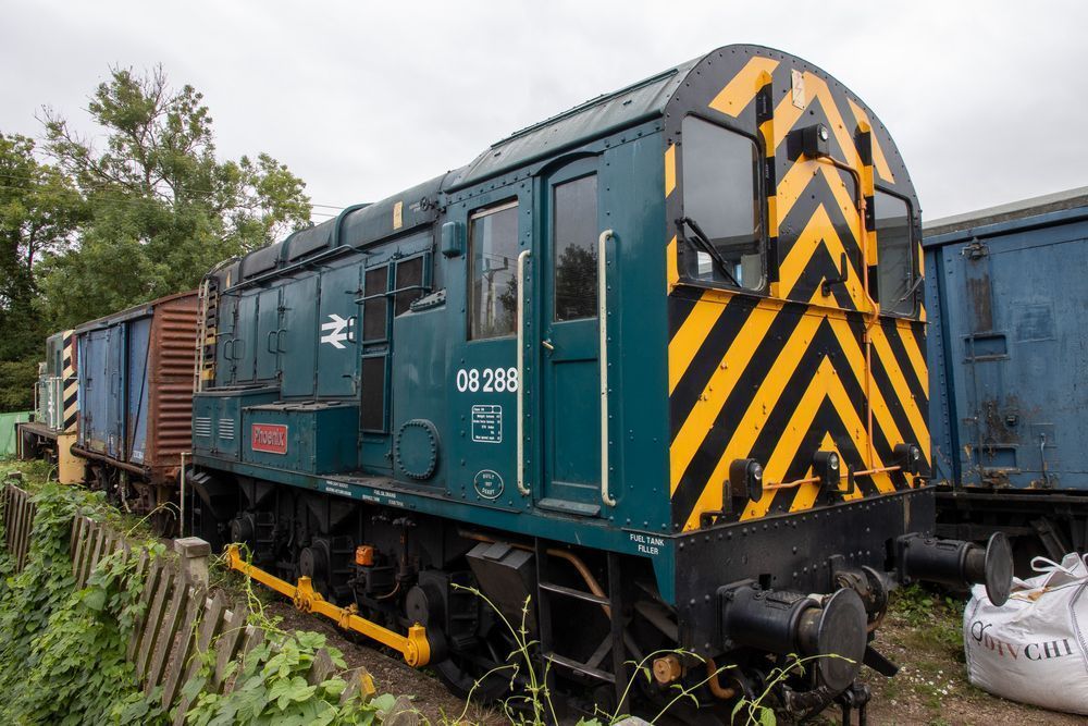 A small locomotive shunter numbered 08288 and named "Phoenix" in BR Blue livery, is seen with some wagons and another small locomotive