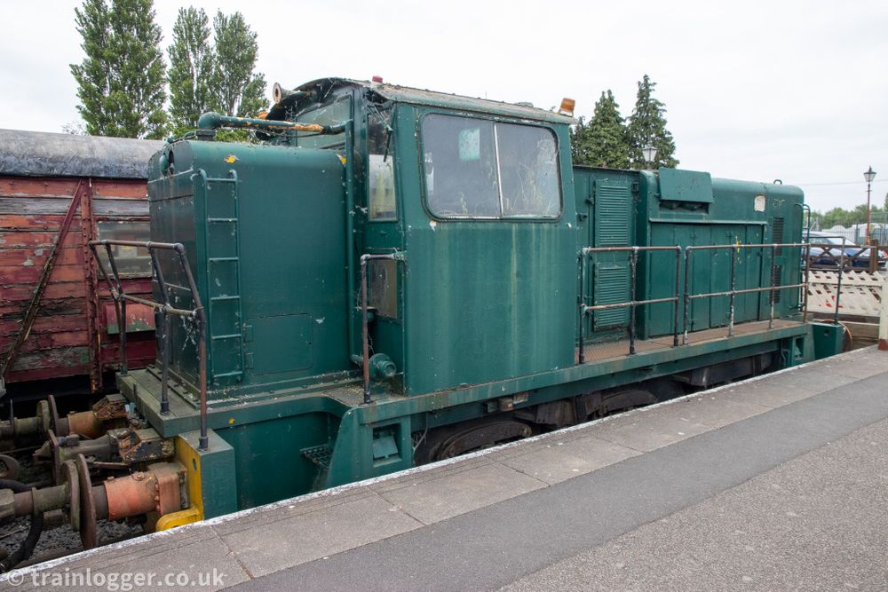 an green General Electric-built locomotive is seen sitting in a platform