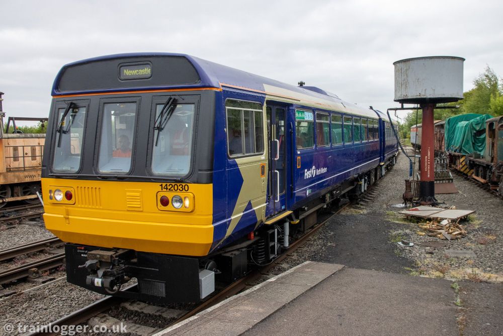 a blue multiple unit ("Pacer") is seen passing an old water tower