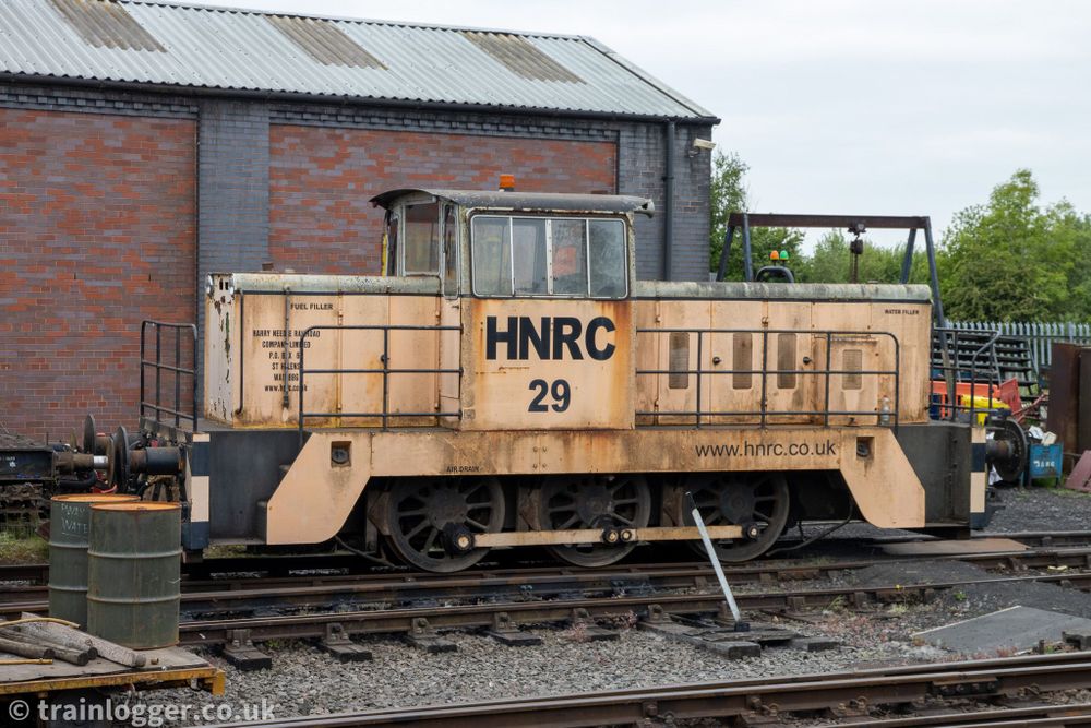 an orange Hunslet-built locomotive is seen sitting in a siding
