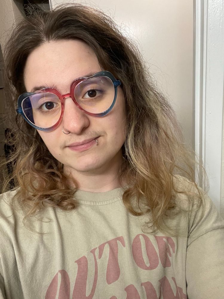 cable wearing heart shaped glasses with plastic rims, pink in the middle and fading to blue towards the temples