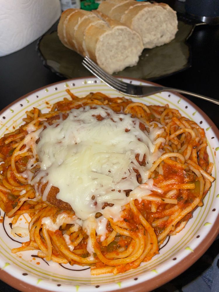 spaghetti with a patty on top with cheese