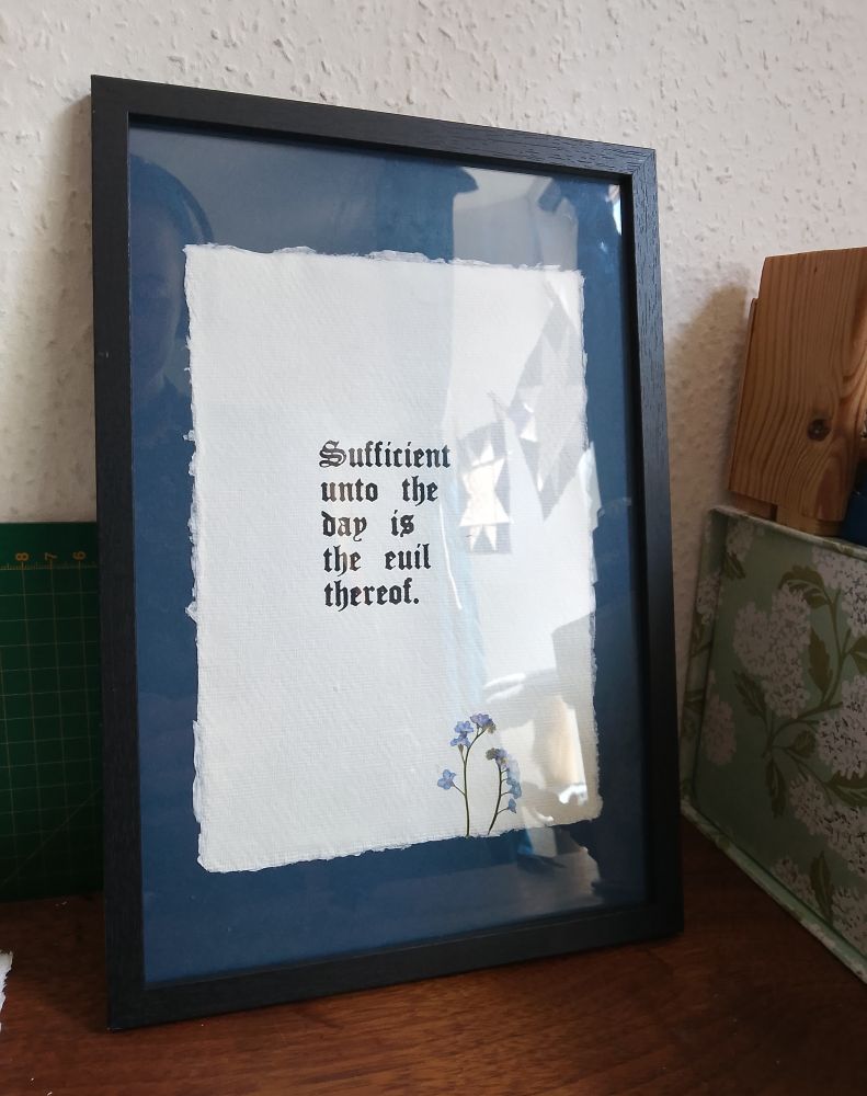 Frames letterpress print that reads "sufficient unto the day is the evil thereof" with pressed forget me nots 
