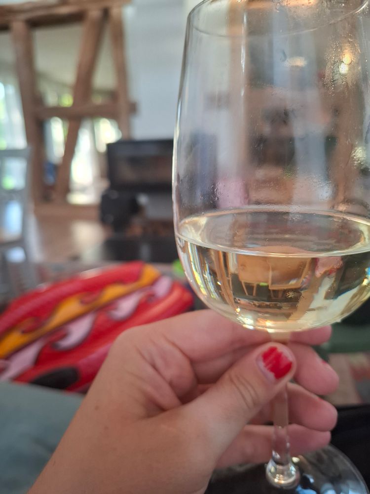 Hand mit Glas, darin ein erfrischendes Kaltgetränk