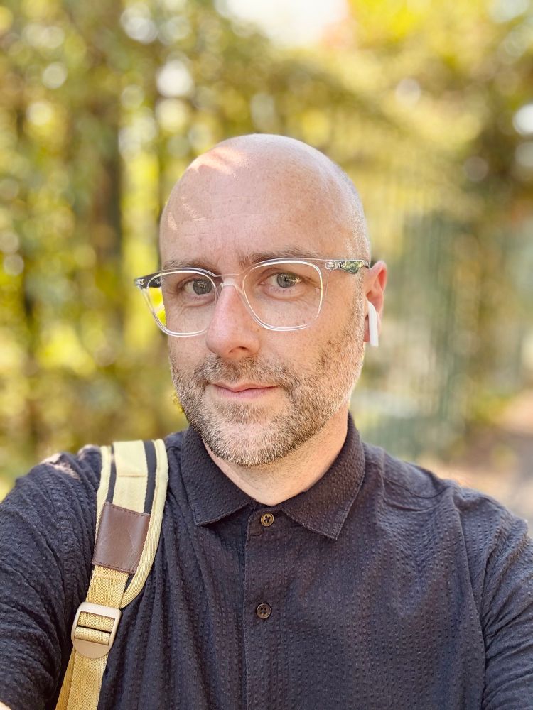 Middle aged norm core dad  wearing clear framed ray-ban glasses like he’s a creative director from 2021