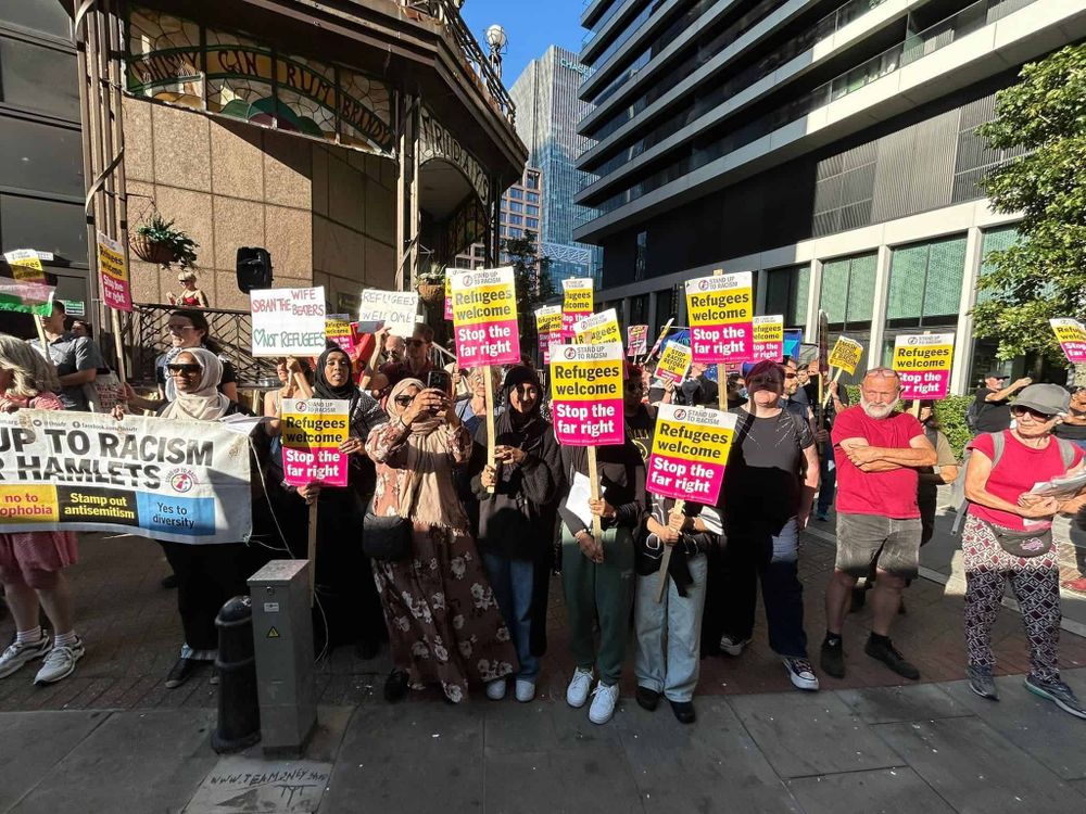 Anti-racist protest with protesters behind a Tower Hamlets Stand Up To Racism banner, and many holding up signs reading "Refugees welcome! Stop the far right!"