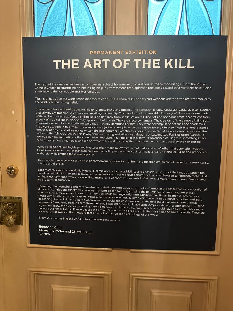 a placard entitled: THE ART OF THE KILL The myth of the vampire has been a controversial subject from ancient civilizations up to the modern age. From the Roman Catholic Church to squabbling drunks in English pubs from famous theologians to teenage girls and boys vampires have fueled a folk legend that cannot die and lives on today. This myth has given the world fascinating works of art. These vampire killing sets and weapons are the strongest testimonial to the validity of this strong belief. People are often confused by the originality of these intriguing objects. The confusion is quite understandable, as often secrecy and privacy are trademarks of the vampire killing community. This conclusion is undeniable. So many of these sets were made under a cloak of secrecy. Vampire killing sets do not grow from seeds. Vampire killing sets do not come from incantations from a book of magical spells. Nor do they appear out of thin air. They are made by humans! The creators of the vampire killing sets were not lone monks in solitude nor were they mentally deranged hermits. They were accomplished artisans and academics that were devoted to this trade. These sets are not just museum pieces to be admired for their beauty. Their intended purpose was to hunt down and kill vampires or vampire collaborators. Sometimes a person suspected of being a vampire was also the victim to this folklorec legacy. This is why vampire hunting and killing was always a private matter. Families often feared the retribution from authorities or the church when exercising their belief in this myth. 