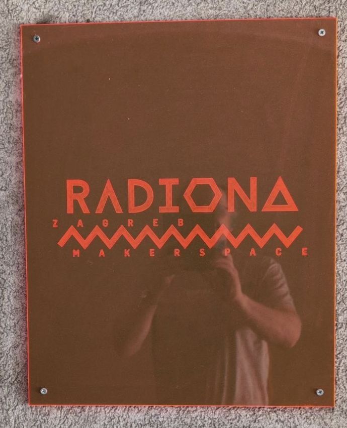 Picture of the Radiona sign with a slight reflection of the guy taking the picture.