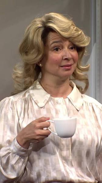 Maya Rudolph holding a coffee cup looking dismayed and confused 