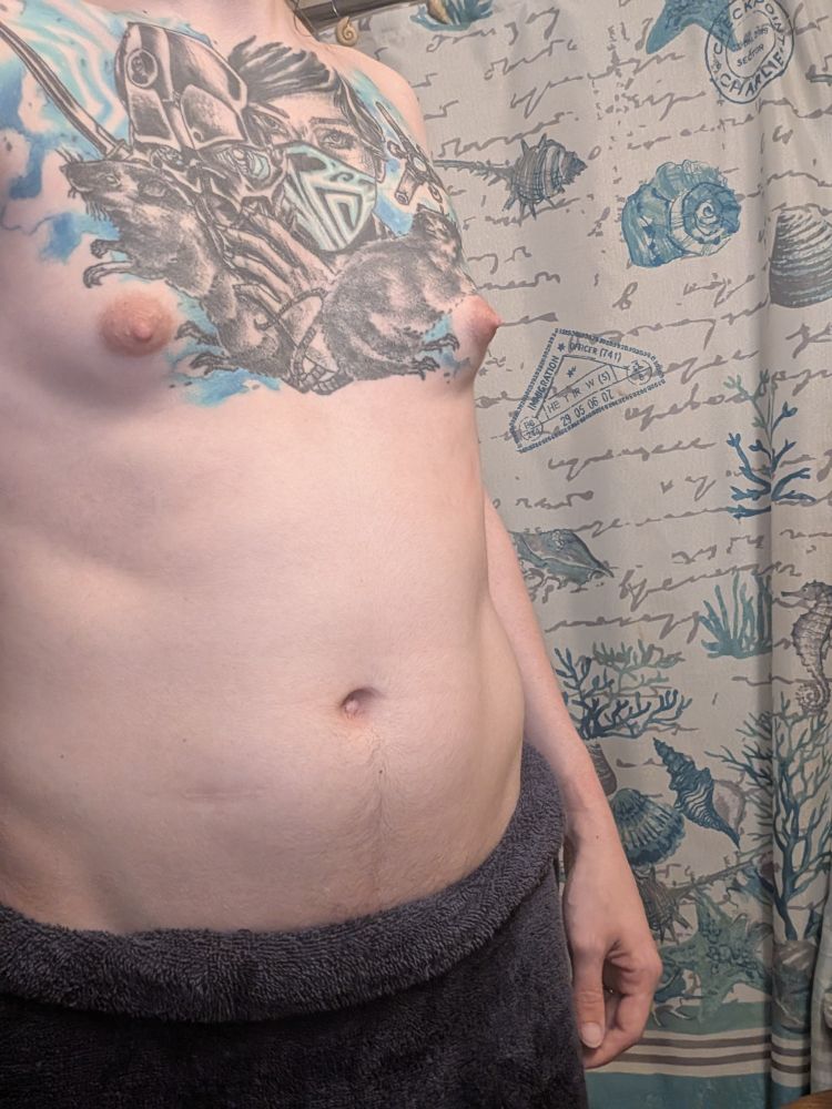 Sophia with a towel wrapped around her hips, showing off everything from the top of the towel up to her collarbones. Her tattoo can be fully seen as well as her tiny tits. 