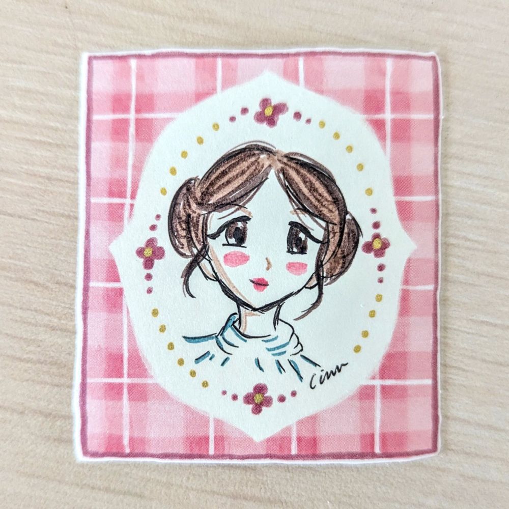 Hand drawn manga style Leia on a pink gingham flake frame sticker. She is inked in color on a ballpoint gel pen sketch