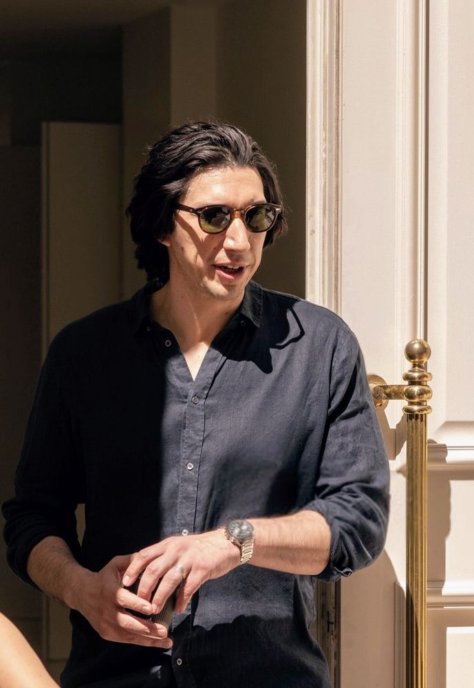 Adam Driver holding a tiny black coffee cup in his hands