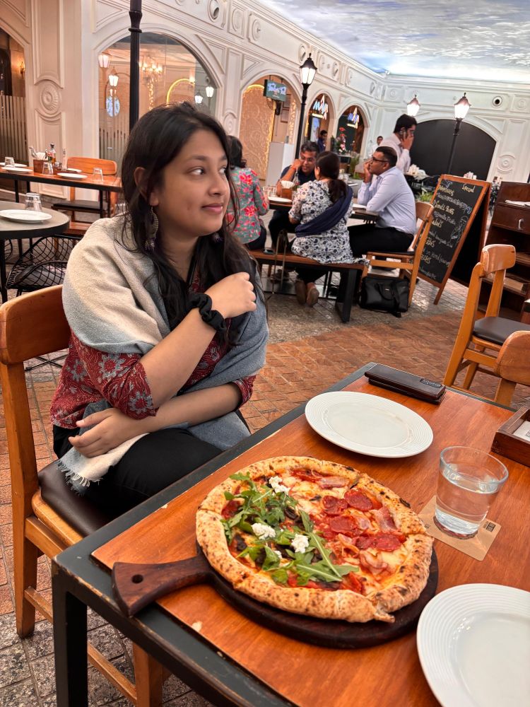 Ira (wearing blue shawl and maroon shirt) tries to act casual about the best pizza she's ever had (feta, arugula, truffle on half and ham and pepperoni on the other half)