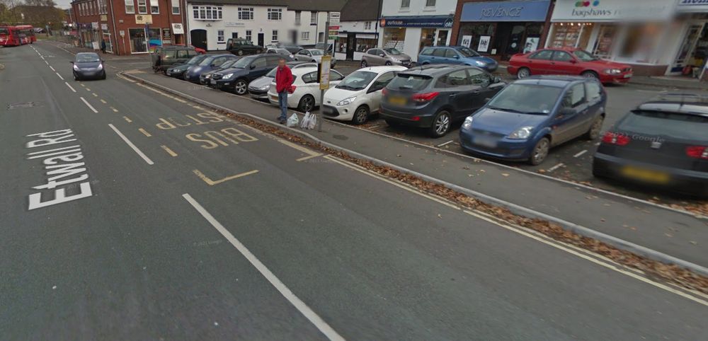 a bus stop floating in front of a car park and access road