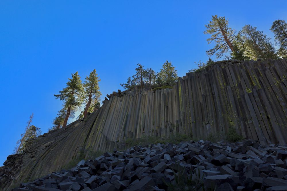 Dramatic thin tall hexagonal rock towers , formed by evenly cooled lava flows 100,000 years ago. Cliff face of columns looks like a washboard. 
