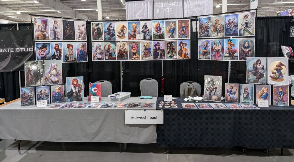 Photo of artist Alley table setup. Displaying prints, metal prints and stickers. 