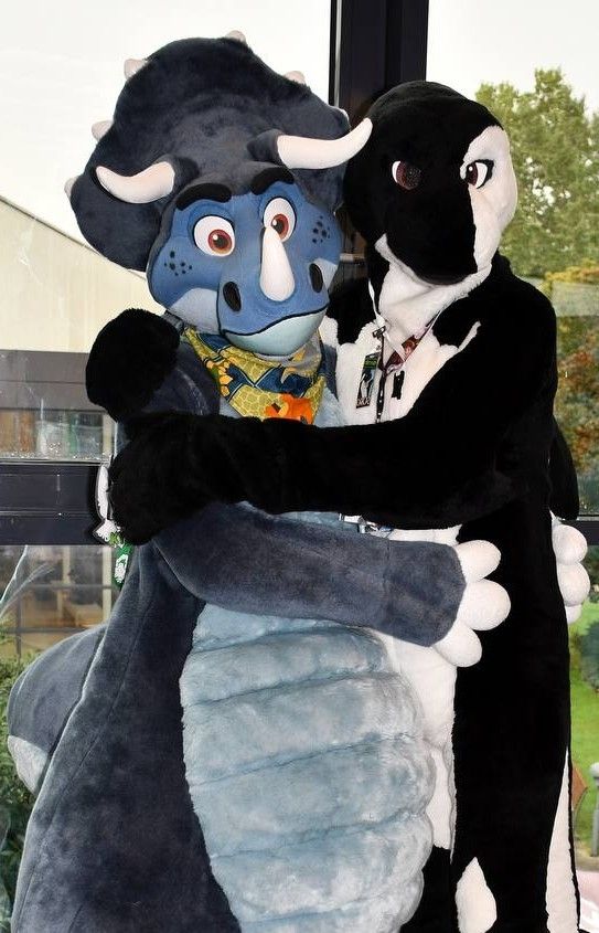 An Orca Fursuit (owner is I) and a Triceratops Fursuit (owner is kyotofox) hugging and facing the camera