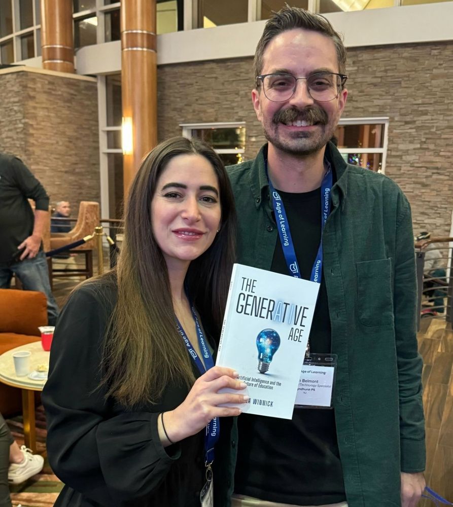 Alana Winnick and Tim Belmont standing together at an event, smiling for the camera. Alana is holding her book titled ‘The Generative Age.’