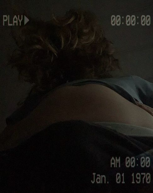 An edited image of Sam. The POV is below her waist, with her bulge visibly straining against her underwear. Her shirt is pulled up to reveal her stomach, and her hair is shrouding her face in darkness. The entire image resembles a found footage tape, with a static-y filter, a timestamp, and PLAY in the top left, not unlike the cursed tape from Ringu.