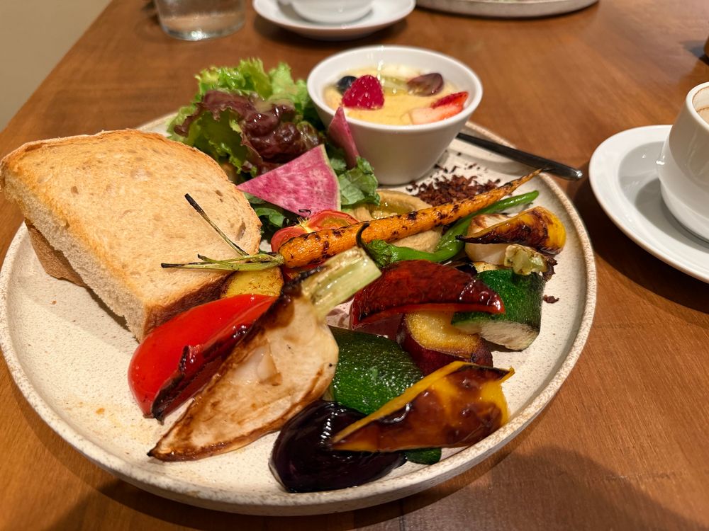 a plate of assorted grilled vegetables with sourdough bread and soy yogurt 