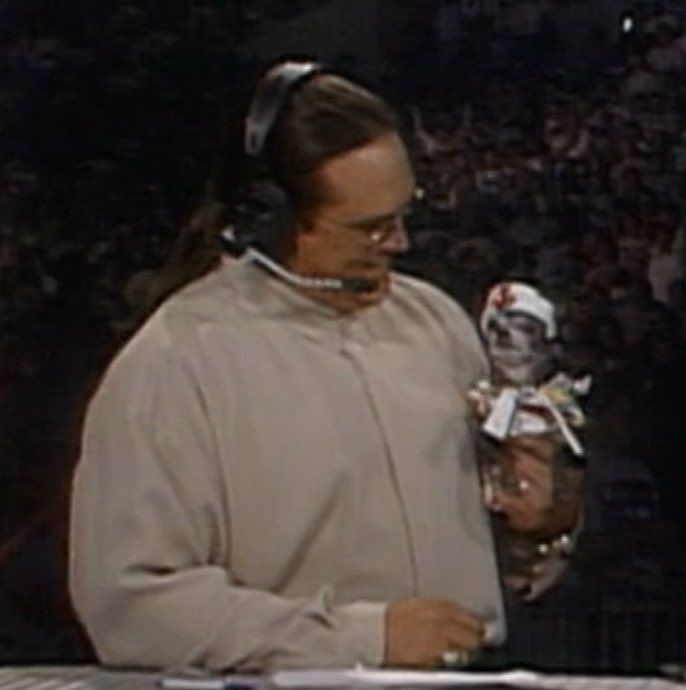 mongo at the wcw monday nitro commentary desk holding pepe and looking down at him with the most loving smile