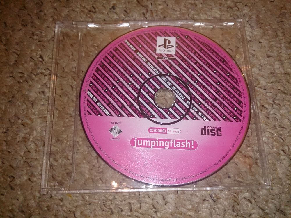 A PAL rental copy of Jumping Flash. Rather than the standard black disc label used by most rental games, this uses a pink design with diagonal stripes indicating its purpose.