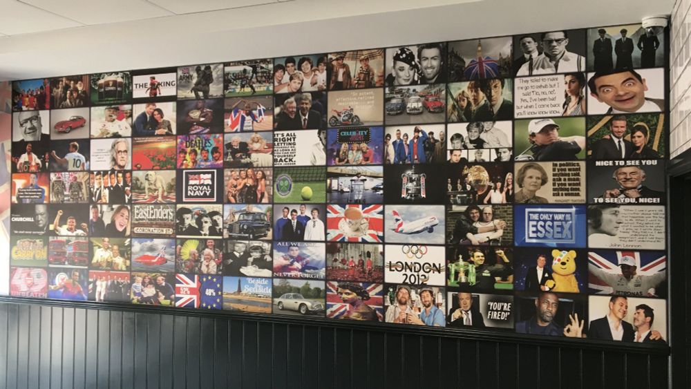 The wall of a chip shop, featuring various images "celebrating" the UK. These include images of Little Britain and Celebrity Juice, a Brexit 52/48, various royals, red buses, a black cab, a cup of tea, people clad head to toe in Burberry and more.