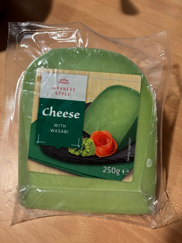 Shrink wrapped cheese that looks like a slab of Edam or Gouda except it is green not yellow. Label says Japanese style Cheese with wasabi.