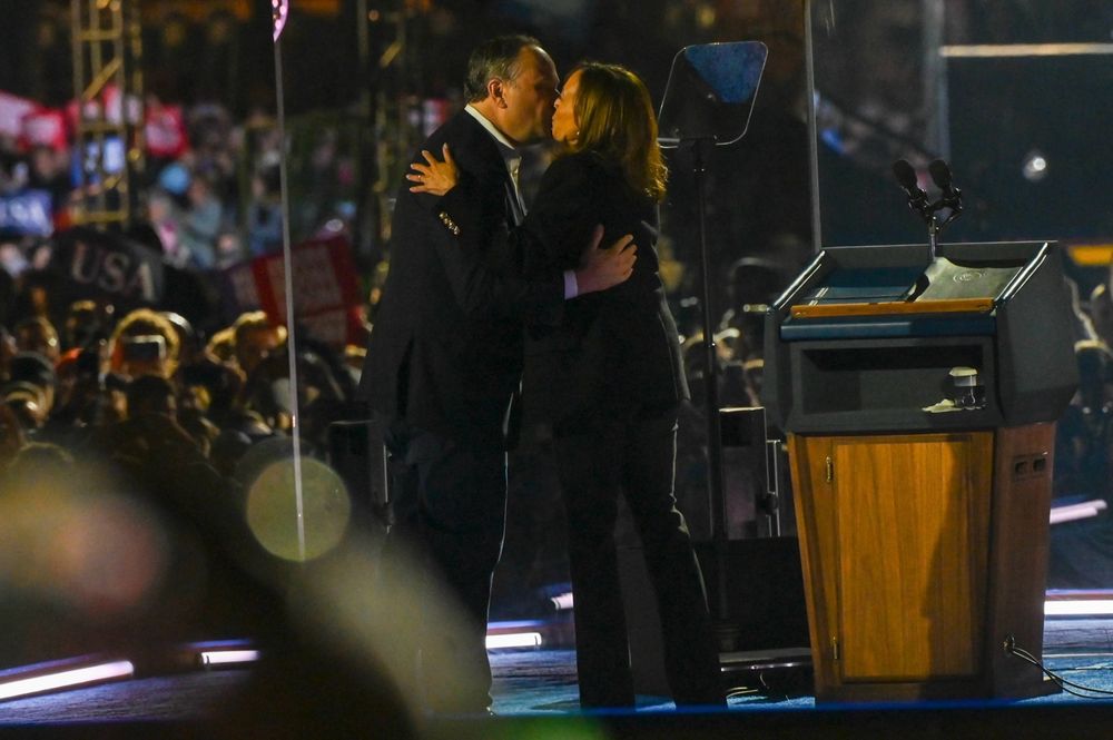 VP Harris and Doug Emhoff share a kiss on stage