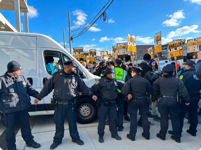 NYPD Police officer holding hands to protect Amazon from a picket strike of union workers.