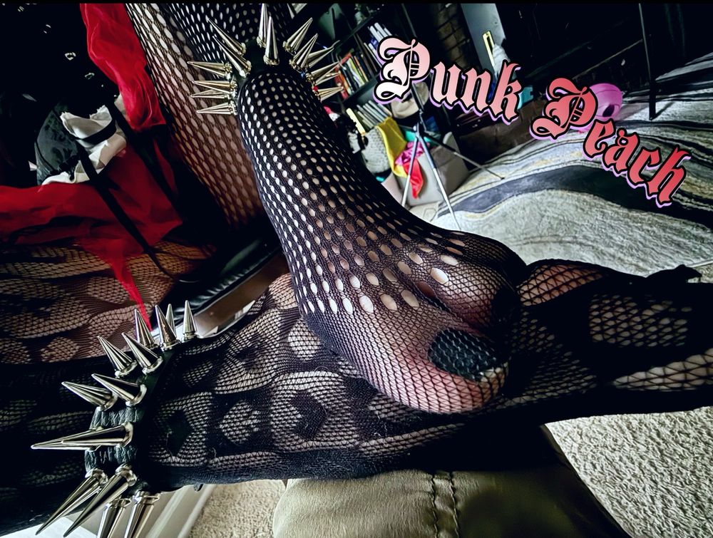 PunkPeach graciously sharing her black painted toes tucked away in fishnets with spiked anklets on