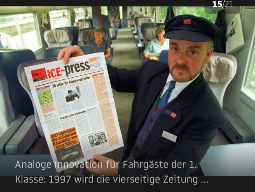 Bild aus der 1. Klasse eines ICE von 1997. Der Schaffner hält eine Ausgabe der ICE-PRESS hoch.