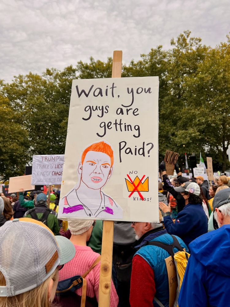A protest poster containing the "Wait, you guys are getting paid?" meme, cleverly drawn.