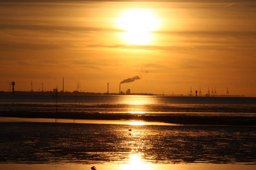 Sonnenuntergangshimmel über dem Watt und dem ablaufenden Meerwasser.