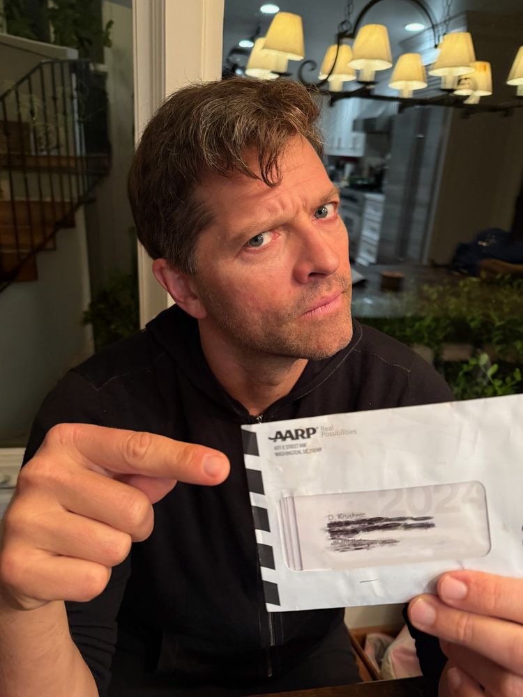 Me pointing to a piece of mail from the AARP. 