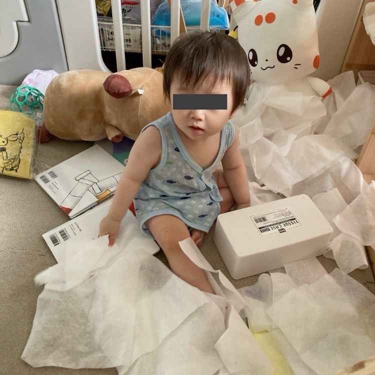 全出ししたティッシュに埋もれて座っている乳児