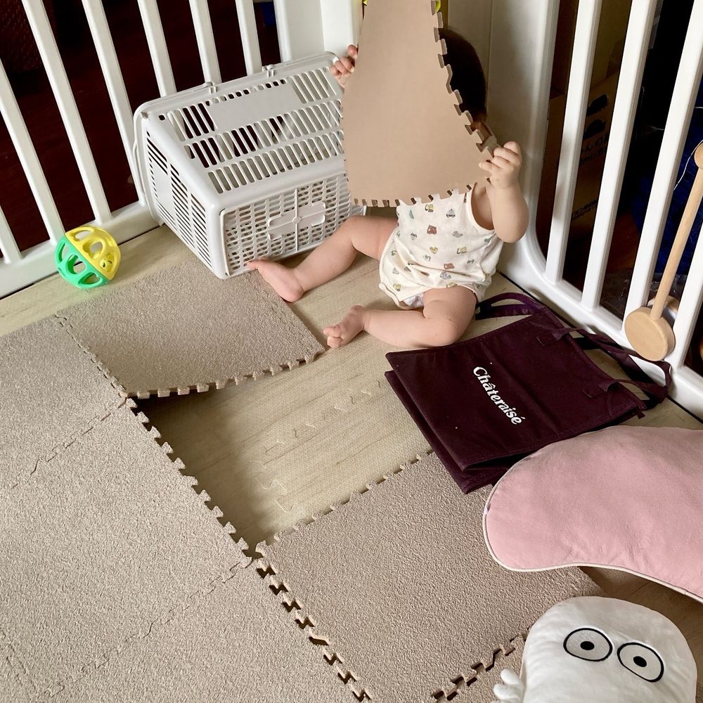 床に敷いてあったジョイントマットを１枚剥ぎ取って、座って眺めている乳児